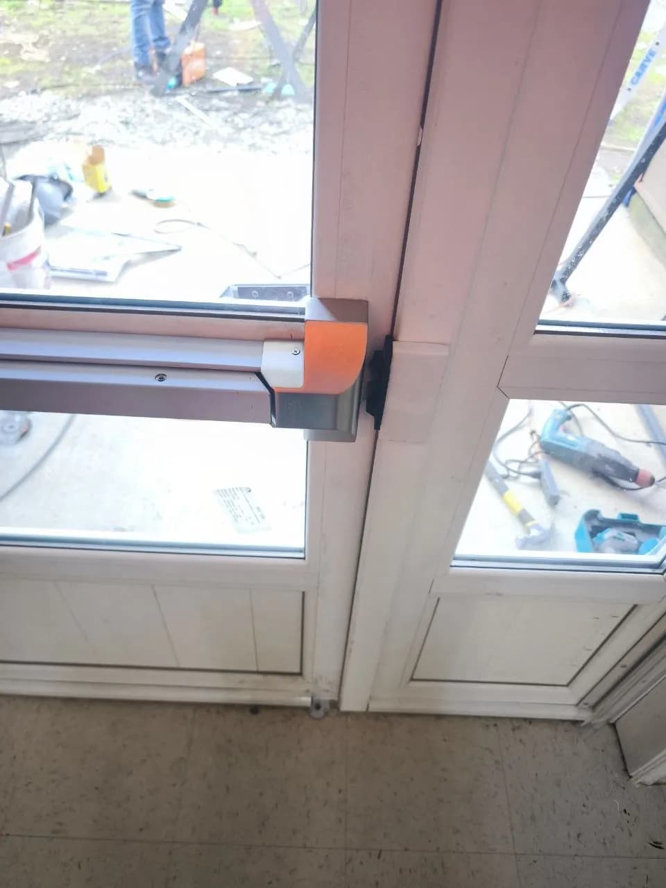 Puerta de acceso comercial con barra antipánico instalada por DM Cristales