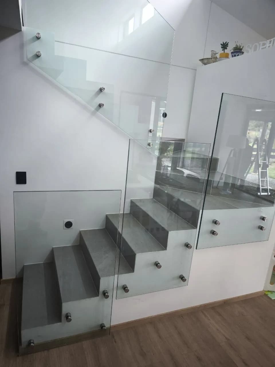 Baranda de cristal templado con botones de acero inoxidable en una escalera, obra de DM Cristales