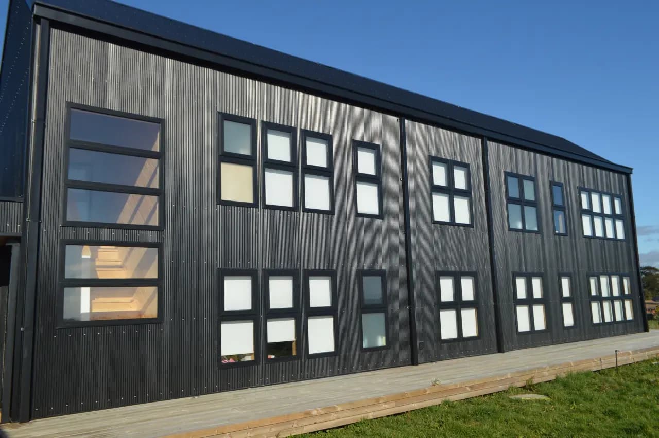 Fachada con ventanas de PVC fijas y proyectantes en serie, obra de DM Cristales