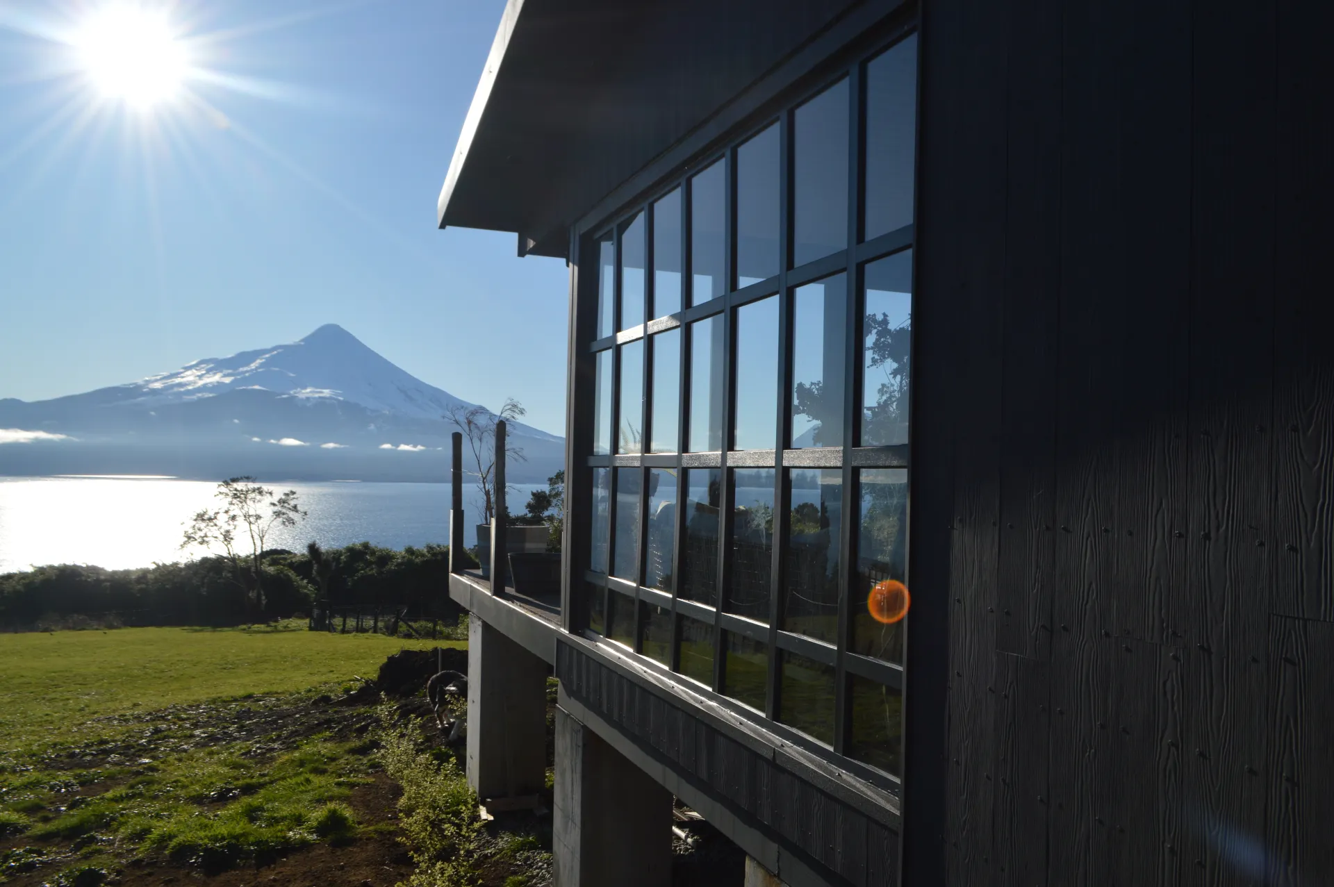 Ventanal panorámico de cristal con vista al Volcán Osorno y al Lago Llanquihue, obra de DM Cristales